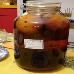 Bocal Le Parfait de rhum 44 maison en cours de macération - orange bio piquée de grains de café immergée dans le rhum ambré, étiquette manuscrite avec la date et le chiffre 44