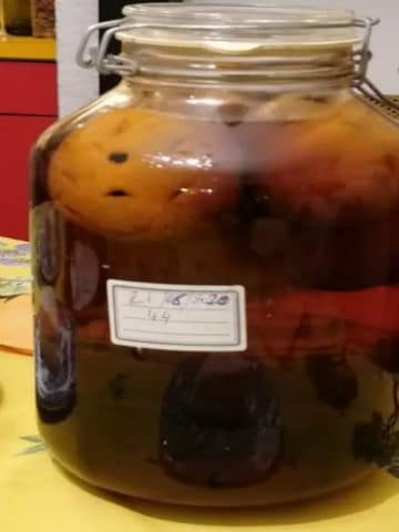 Bocal Le Parfait de rhum 44 maison en cours de macération - orange bio piquée de grains de café immergée dans le rhum ambré, étiquette manuscrite avec la date et le chiffre 44