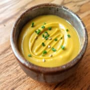 Sauce moutarde crémeuse dans un bol rustique, garnie de persil et graines de moutarde