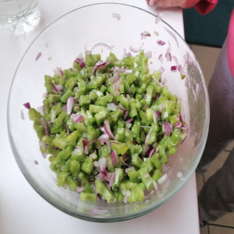 mélange de l'oignon ciselé et des morceaux de rougail margose dans un saladier
