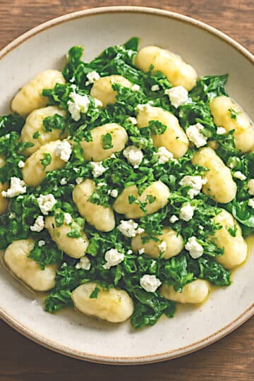 Assiette de gnocchis sans gluten aux épinards, feta, persil frais et filet d'huile d'olive