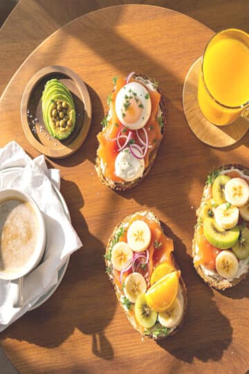 Petit-déjeuner maison avec tartines sucrées et salées, café, jus d'orange et pain grillé sur table en bois rustique