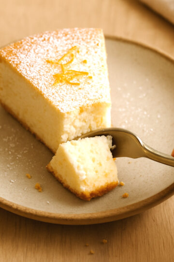 gâteau léger au fromage blanc, moelleux, coupée à la fourchette sur assiette rustique