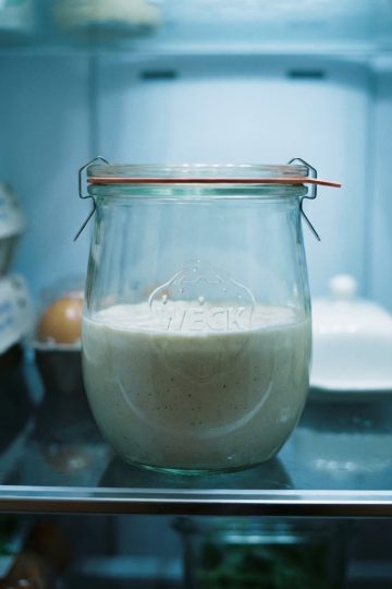 Bocal de levain chef fermé hermétiquement, stocké sur une étagère dans un réfrigérateur pour une conservation au froid