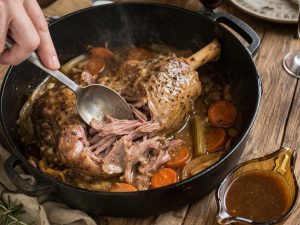 Gigot d'agneau de 7 heures servi à la cuillère directement dans la cocotte, viande fondante et effilochée