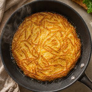 Les bords commencent à dorer et croustiller, de légères bulles d'huile sont visibles sur le pourtour