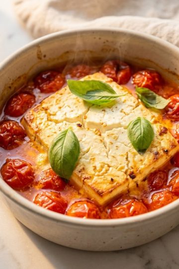 Plat de pâtes à la feta au four avec tomates cerises éclatées et basilic frais