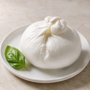 Burrata fraîche entière sur assiette blanche, prête à être dressée