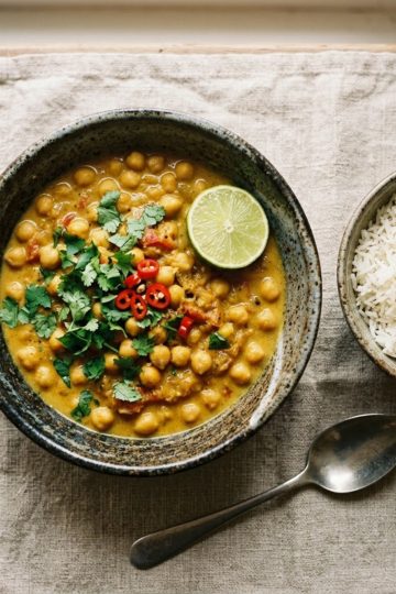 Curry de pois chiches express au lait de coco, servi dans un bol en céramique avec riz basmati et coriandre fraîche
