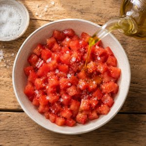 Dés de tomates fraîches assaisonnés à l'huile d'olive dans un saladier en céramique