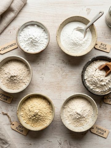 Différentes farines de substitution dans des bols : maïzena, riz, châtaigne, sur plan de travail
