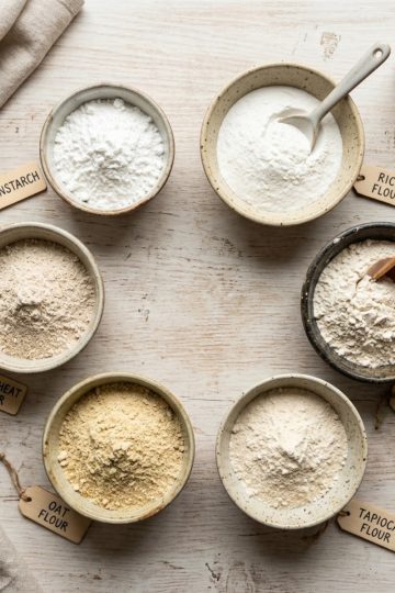 Différentes farines de substitution dans des bols : maïzena, riz, châtaigne, sur plan de travail