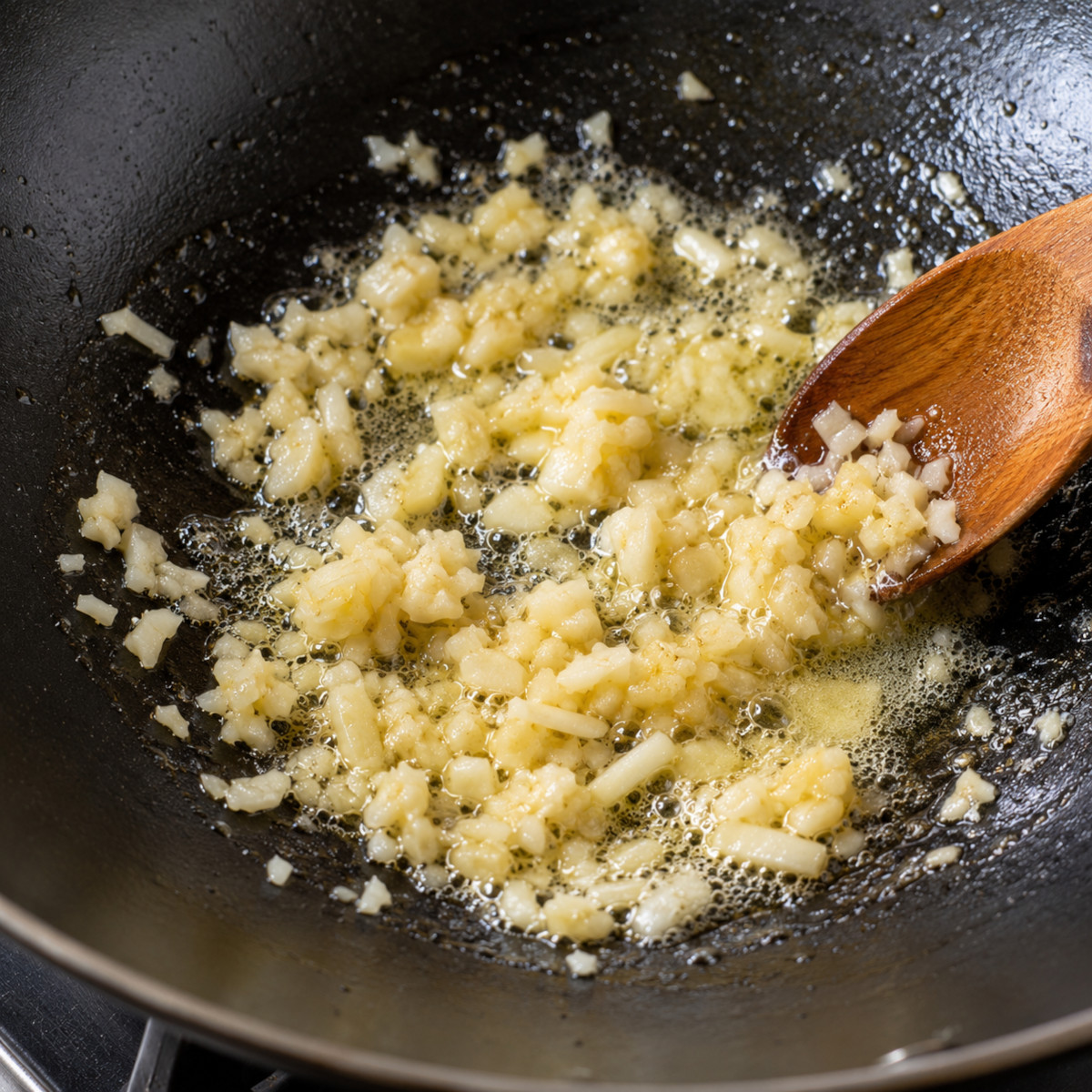 Ail haché fondant doucement dans le beurre au wok