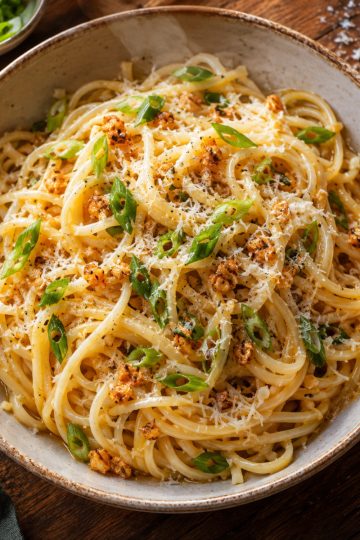 Assiette de garlic noodles parsemées de cébette et de parmesan