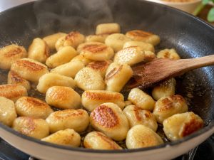 Gnocchis frais en train de dorer dans une poêle avec huile et beurre