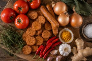 Ingrédients frais du rougail saucisse vegan sur une planche en bois