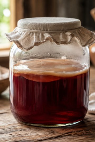 Mère de vinaigre translucide flottant à la surface d'un bocal de vinaigre de vin maison