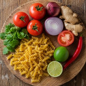 Tomates, oignon, gingembre et piment frais posés sur une planche en bois