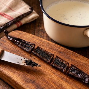 Gousse de vanille fendue et coupée en quatre au-dessus d'une casserole de lait