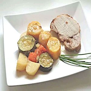 Rôti de porc au four aux légumes de saison, tranché dans sa cocotte avec courgettes, carottes et pommes de terre