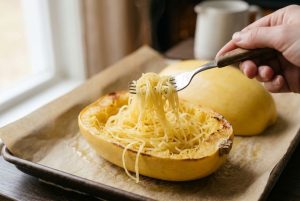 Fourchette détachant les filaments dorés de la courge cuite