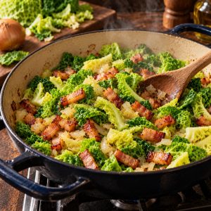 Lanières de chou de Milan qui tombent dans la sauteuse avec les lardons dorés